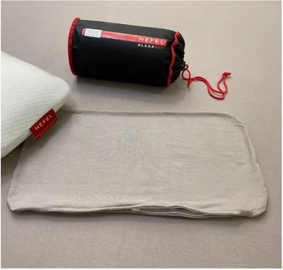 A pillow and its accessories are laid out on a neutral surface.