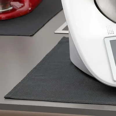 A close-up shot of a kitchen appliance on a counter, with a placemat underneath.