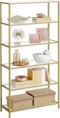 A gold and glass shelving unit with various decorative items and boxes displayed on its shelves.