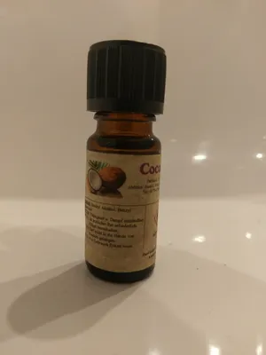 Kleine braune Flasche mit einem schwarzen Verschluss. Auf dem Etikett steht "Coco".
