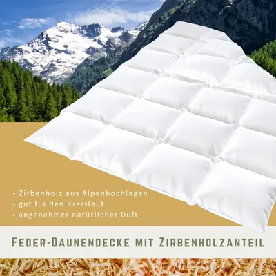 A white comforter is displayed diagonally in front of a mountain landscape with trees.