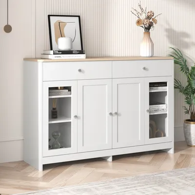 A white sideboard with a wooden top, decorated with books, a vase with flowers, and a plant.