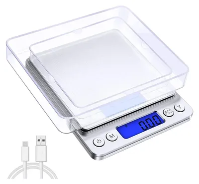 A digital kitchen scale with a transparent cover and a USB charging cable.