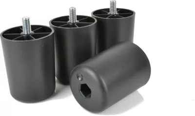 Four black furniture feet are arranged diagonally against a white background, with one in the foreground tilted on its side.