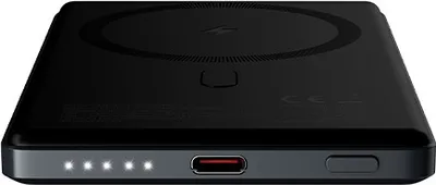 A black power bank with a wireless charging surface and indicator lights is shown from a slightly elevated front-left angle.