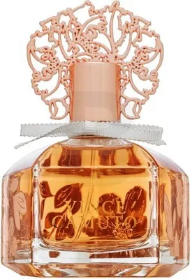 A perfume bottle with a decorative rose gold cap and a white ribbon around the neck.