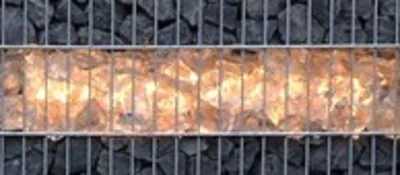 A close-up view of a gabion wall with a lit section in the middle.