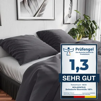 A bed with dark gray bedding and pillows, with a promotional badge on the right.