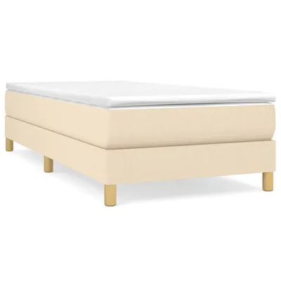 A studio shot of a box spring bed frame with a white mattress topper.