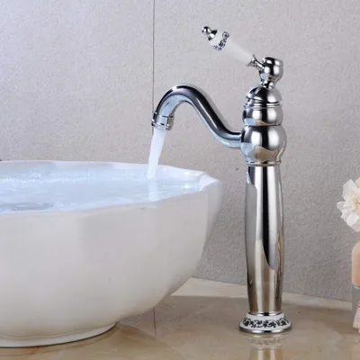 A chrome faucet with a white handle is running water into a white sink.