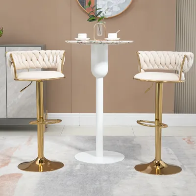 Two beige bar stools are placed on either side of a small round table with a white base.