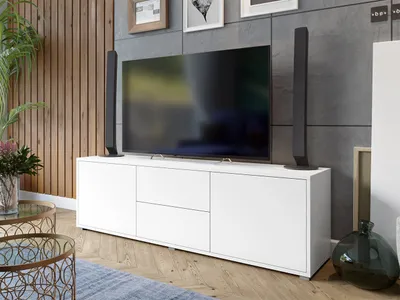 A modern living room with a TV stand, television, speakers, and coffee tables.