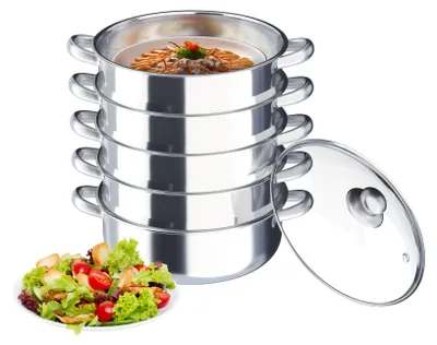 A stack of stainless steel steaming pots with a glass lid and a salad in a bowl.