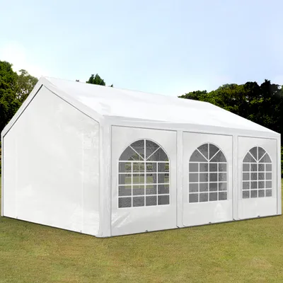 A white party tent is set up on a grassy lawn with trees in the background under a clear sky.