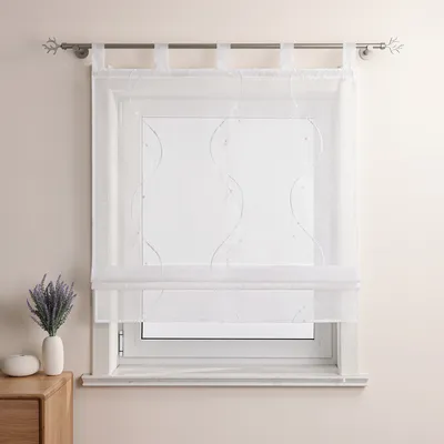 A white sheer Roman blind with embroidered wavy lines and beads is installed on a window.