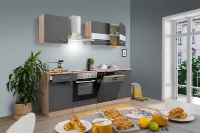 A modern kitchen setup with cabinets, appliances, and a dining table with food.