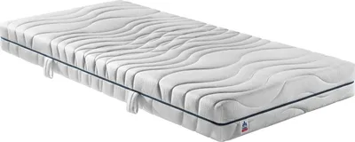 A white mattress with a wavy pattern on its surface, lying on a white background.