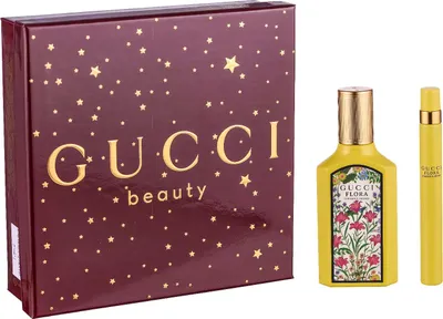 A Gucci beauty gift set containing a perfume bottle and a travel-sized spray, presented with a decorative box.