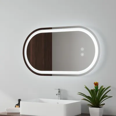 A modern bathroom vanity with a rectangular sink, a faucet, and a decorative plant next to a large oval mirror with integrated LED lighting.
