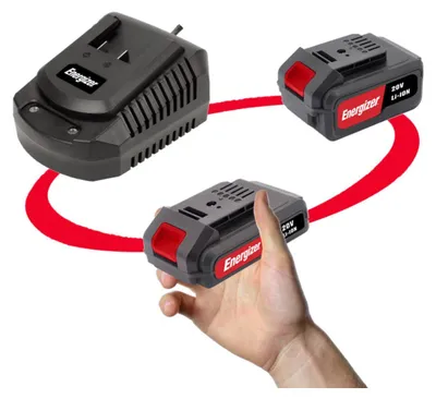 A charger and two batteries for a power tool are shown, with one battery being held by a hand.
