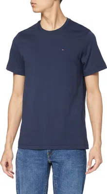 A man wearing a navy blue t-shirt and blue jeans.