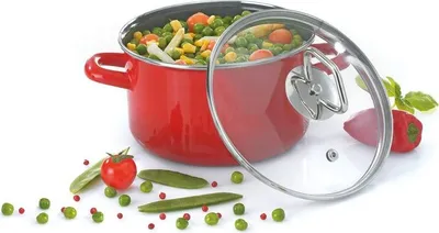 A red pot filled with mixed vegetables, with a glass lid slightly ajar. Scattered around the pot are fresh vegetables like peas, a tomato, and bean pods.
