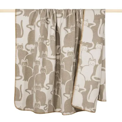 A blanket with a cat pattern is draped over a wooden rod.