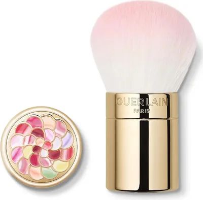 A makeup brush and its compact case are displayed against a white background.