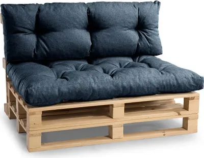 A close-up studio shot of a two-seater sofa made from wooden pallets with blue cushions.