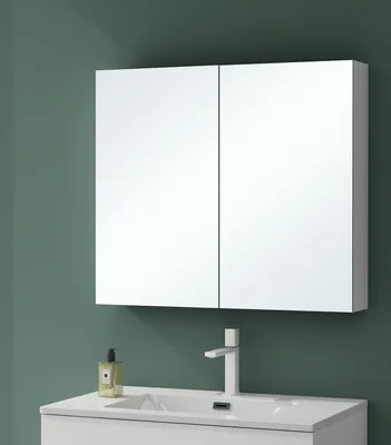 A white mirrored cabinet with two doors is mounted above a white sink and faucet.