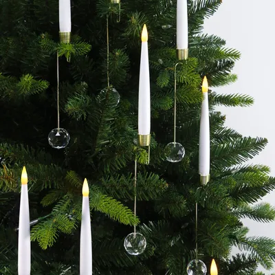 Close-up of LED Christmas tree candles and crystal ornaments hanging on a Christmas tree.