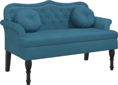 A studio shot of a blue velvet bench with decorative studs and two round cushions.