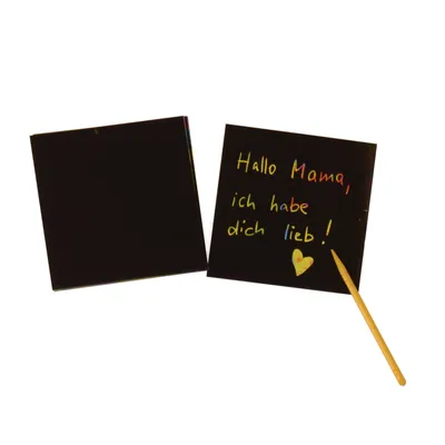 Two black scratch paper cards are shown against a white background. One card is blank, and the other has colorful writing and a heart drawn on it, with a wooden stylus resting on it.