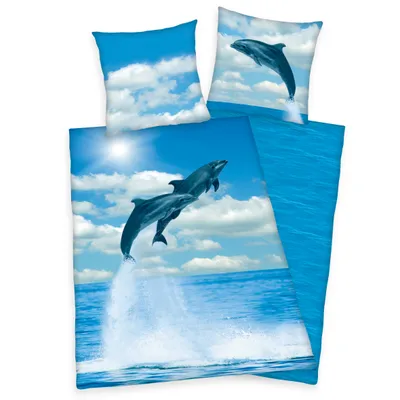 A bedding set with dolphins jumping out of the water, set against a blue sky with clouds.