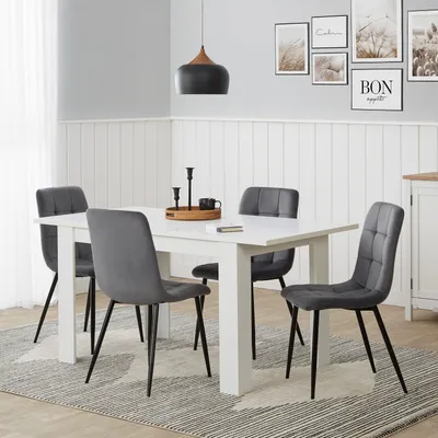 A dining room scene with a white table and four gray chairs.
