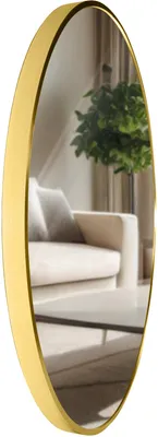 A round gold mirror reflecting a living room scene with a sofa and a plant.