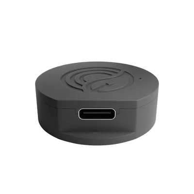 A close-up view of a black, round electronic device with a USB-C port and a logo on top.