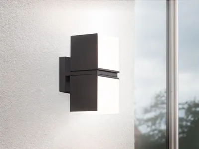 A modern outdoor wall light mounted on a textured white wall, next to a window.