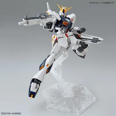 A model of a Gundam robot in a dynamic pose, held up by a clear plastic stand.