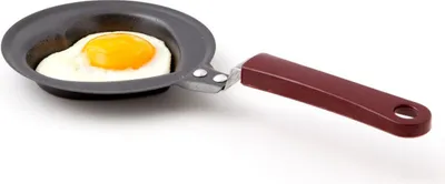 A single fried egg in a mini heart-shaped frying pan.