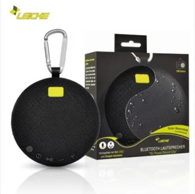 A product shot of a black portable Bluetooth speaker and its packaging.