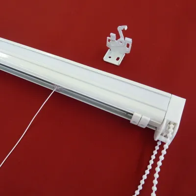 A white roller blind mechanism with a pull chain is shown against a red background.