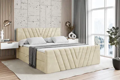 A bedroom scene with a beige upholstered bed.