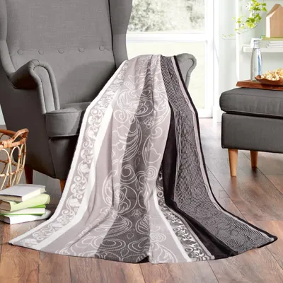 A blanket is draped over a chair in a living room setting.