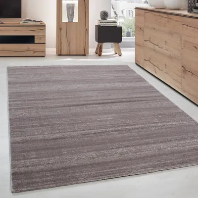 A rug is placed on a floor in a room with furniture.