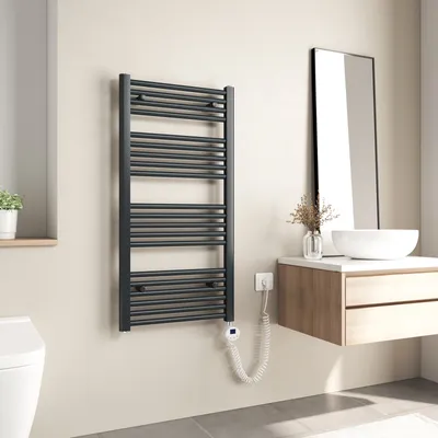 A modern bathroom with a dark grey electric towel warmer mounted on a light-colored wall.