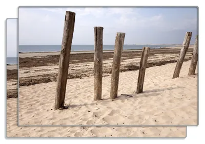 Produktbild von Wallario Frühstücksbrettchen 2er Set aus Glas, je 20 x 30 cm, mit rutschfesten Füßen, Motiv Sandstrand mit Holzpfählen am Atlantischen Ozean