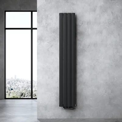 A modern bathroom radiator mounted on a concrete wall next to a large window.