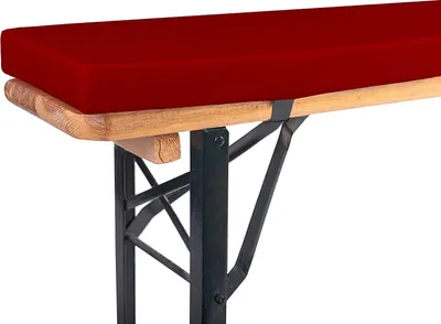 A close-up view of a red bench cushion on a wooden bench with black metal legs.