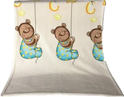 A baby blanket with a pattern of teddy bears hanging from strings, with moons and stars.